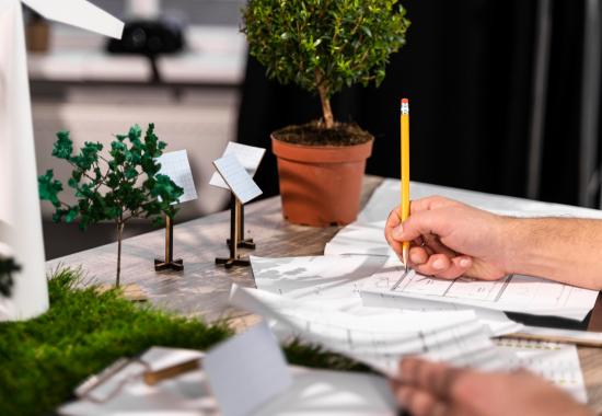 image d'illustration représentant un homme entrain de concevoir un projet avec des objets de décoration rappellant l'écologie