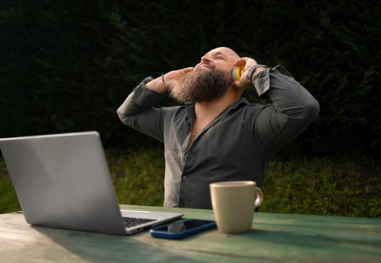 Image d'un homme heureu qui écoute de la musique tout en travaillant en extérieur.
