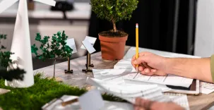 image d'illustration représentant un homme entrain de concevoir un projet avec des objets de décoration rappellant l'écologie