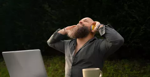 Image d'un homme heureu qui écoute de la musique tout en travaillant en extérieur.