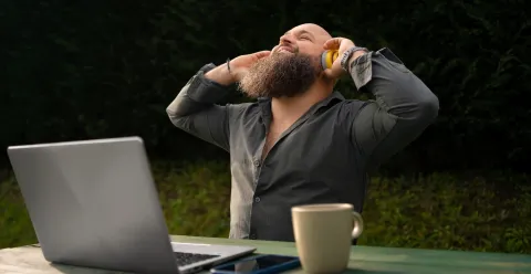 Image d'un homme heureu qui écoute de la musique tout en travaillant en extérieur.
