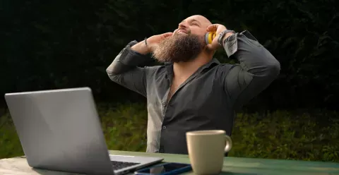 Image d'un homme heureu qui écoute de la musique tout en travaillant en extérieur.