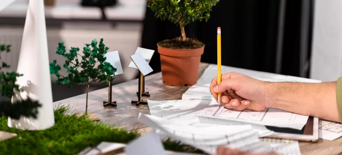 image d'illustration représentant un homme entrain de concevoir un projet avec des objets de décoration rappellant l'écologie