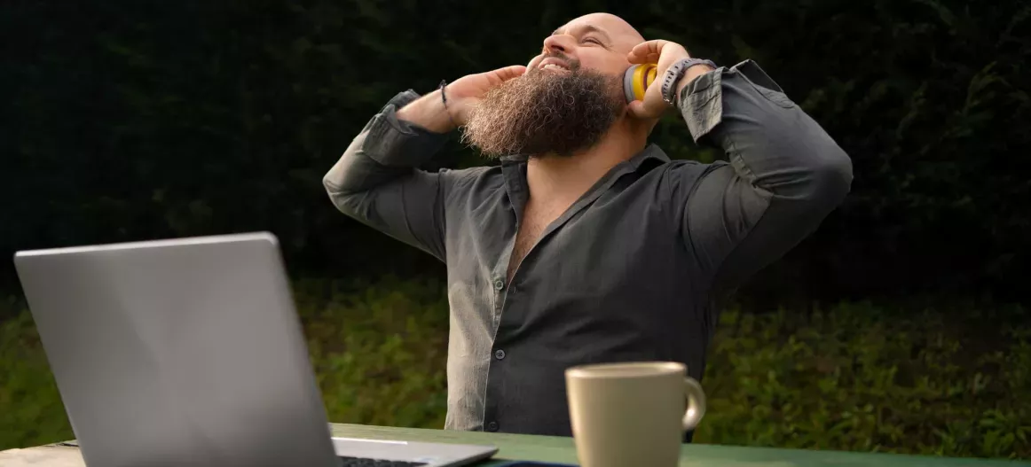 Image d'un homme heureu qui écoute de la musique tout en travaillant en extérieur.